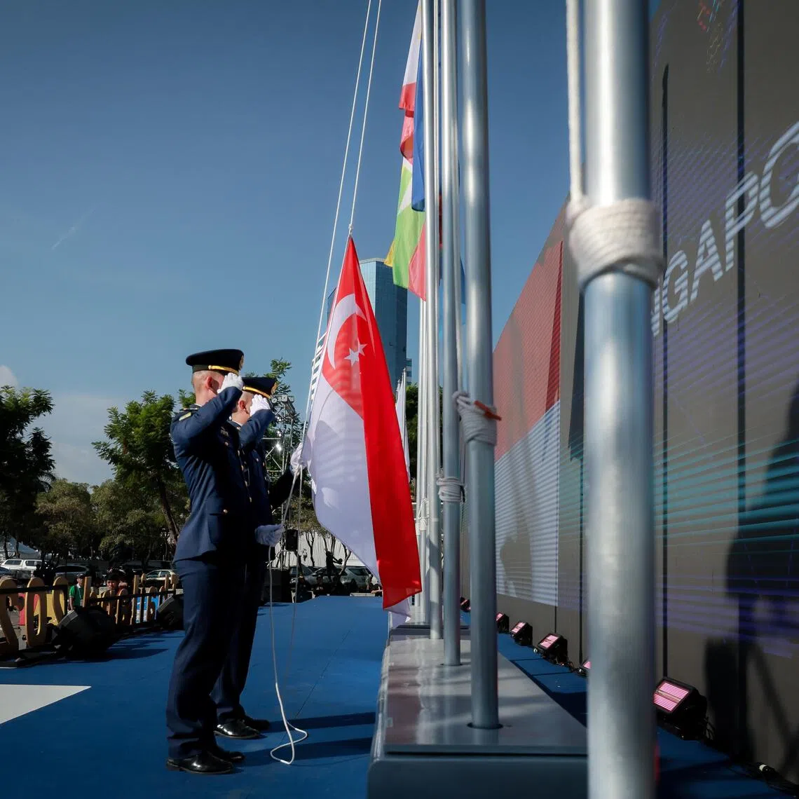 Ceremonial guards raising the Singapore flag at the SEA Games national flag raising ceremony at the open area beside Hua Mark Indoor Stadium on Dec 8, 2025.