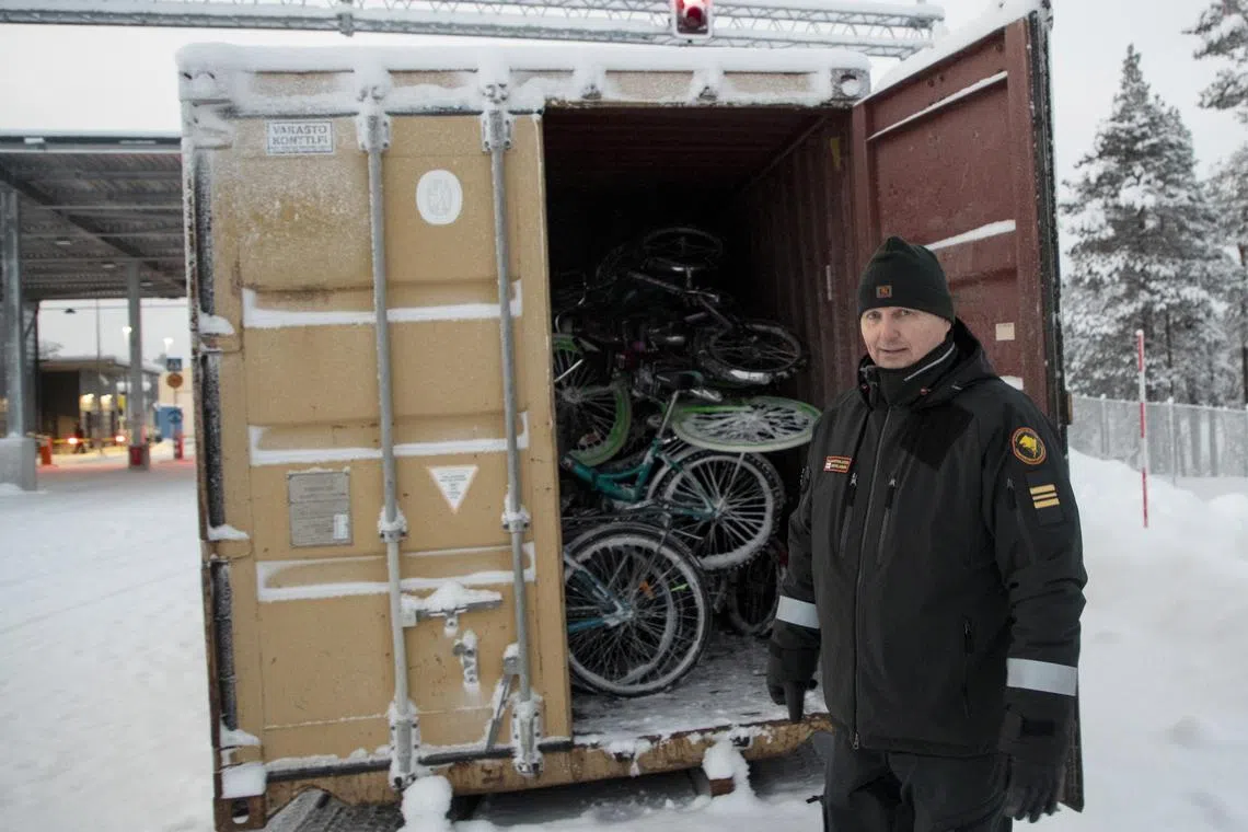 A border guard in neighbouring Finland shows a container full of bicycles used by migrants to cross the border from Russia.