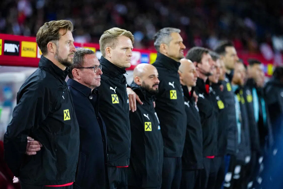 Austria coach Ralf Rangnick (2nd left) and staff singing the national anthem before the friendly against Turkey in Vienna on March 26, 2024.