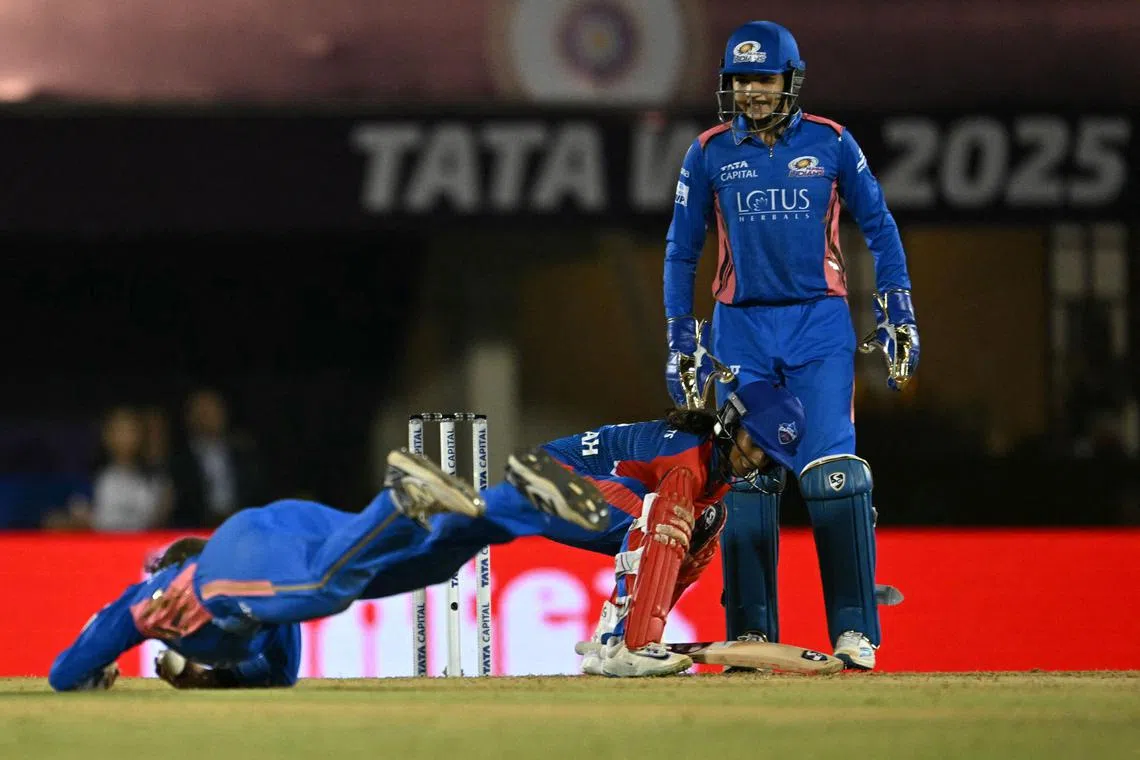 Mumbai Indians' Amelia Kerr takes the catch to dismiss Delhi Capitals' Jemimah Rodrigues as Mumbai wicket-keeper Yastika Bhatia watches in the Women's Premier League (WPL) Twenty20 final at Brabourne Stadium in Mumbai on March 15, 2025.