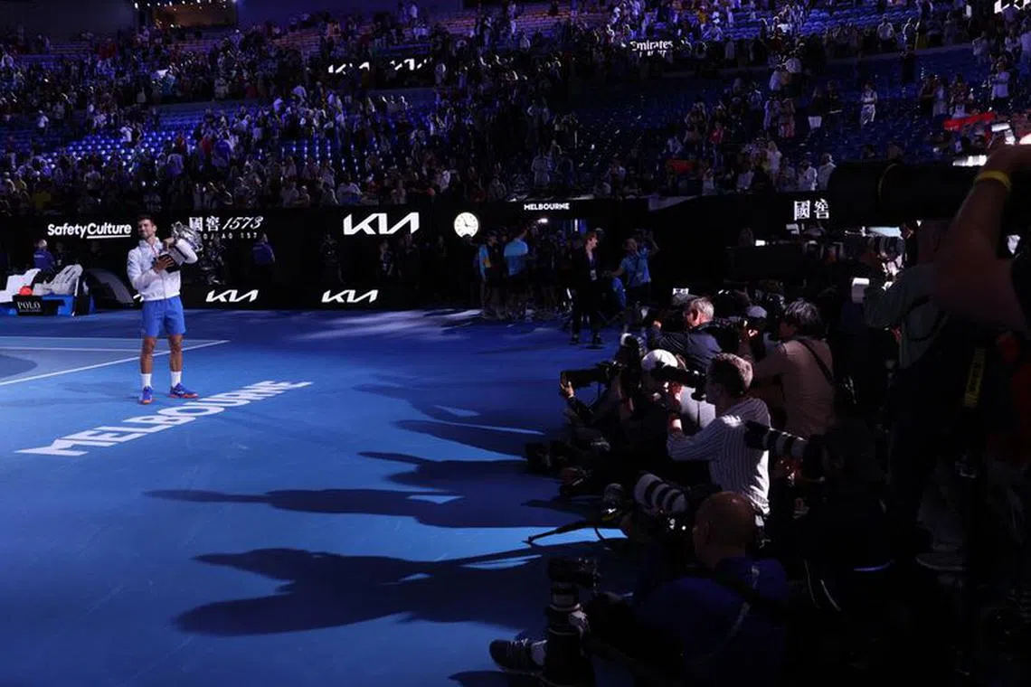 Tennis - Australian Open - Men's Singles Final - Melbourne Park, Melbourne, Australia - January 29, 2023 Serbia's Novak Djokovic is photographed by the media as he celebrates with the trophy after winning his final match against Greece's Stefanos Tsitsipas REUTERS/Loren Elliott/File Photo