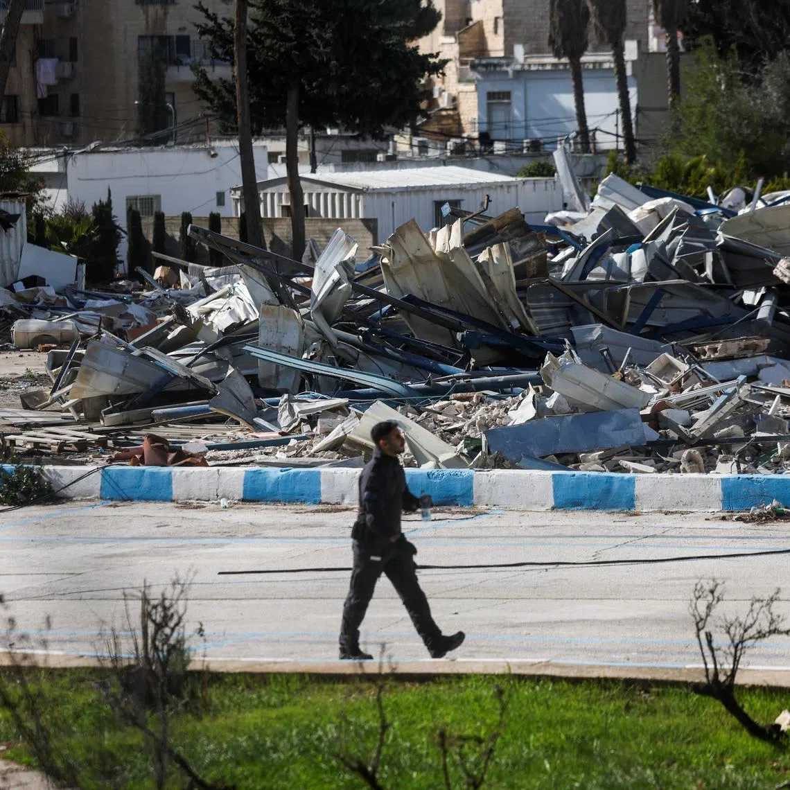 A member of the Israeli forces walks past the rubble of a dismantled structure at the Jerusalem headquarters of the United Nations Relief and Works Agency for Palestine Refugees (UNRWA), in East Jerusalem, January 20, 2026. REUTERS/Ammar Awad