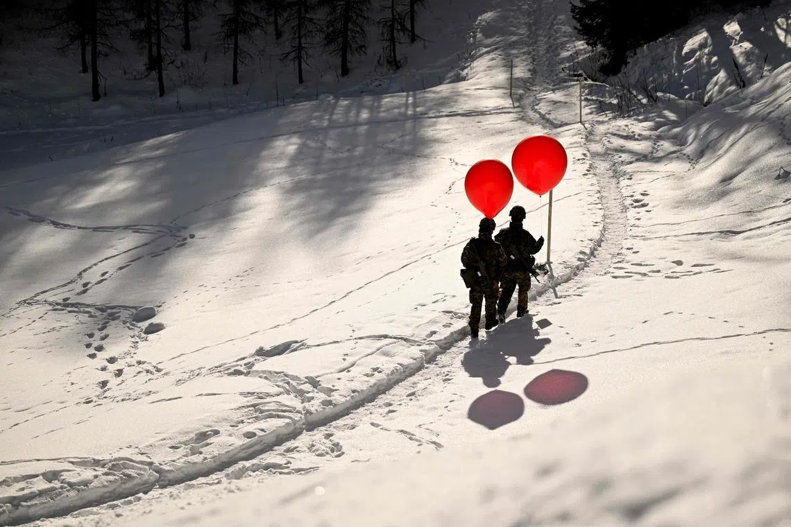 Soldiers holding weather balloons are seen during the World Economic Forum (WEF) annual meeting in Davos, Switzerland on Jan 22, 2026. The World Economic Forum takes place in Davos from Jan 19 to 23, 2026. 