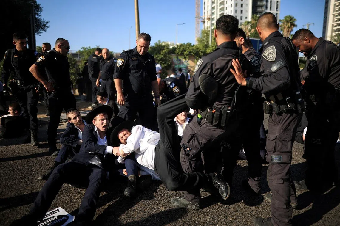 FILE PHOTO: Israeli police take away Ultra-Orthodox Jews while people blocking a road take part in a protest against pressure to conscript into the military in Bnei Brak, Israel, June 5, 2025.  REUTERS/Itai Ron/File Photo