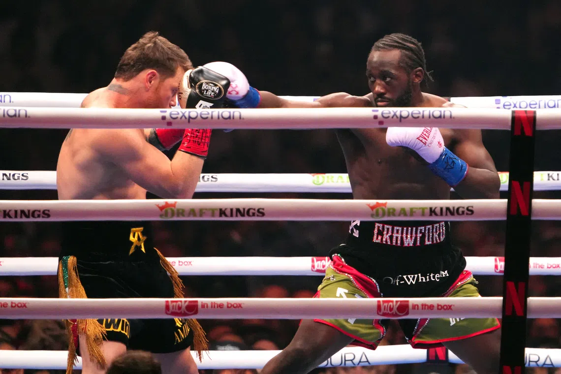 Sep 13, 2025; Las Vegas, Nevada, USA; Canelo Alvarez (black/gold trunks) and Terence Crawford (black/red trunks) box during their super middleweight title bout  at Allegiant Stadium. Mandatory Credit: Joe Camporeale-Imagn Images