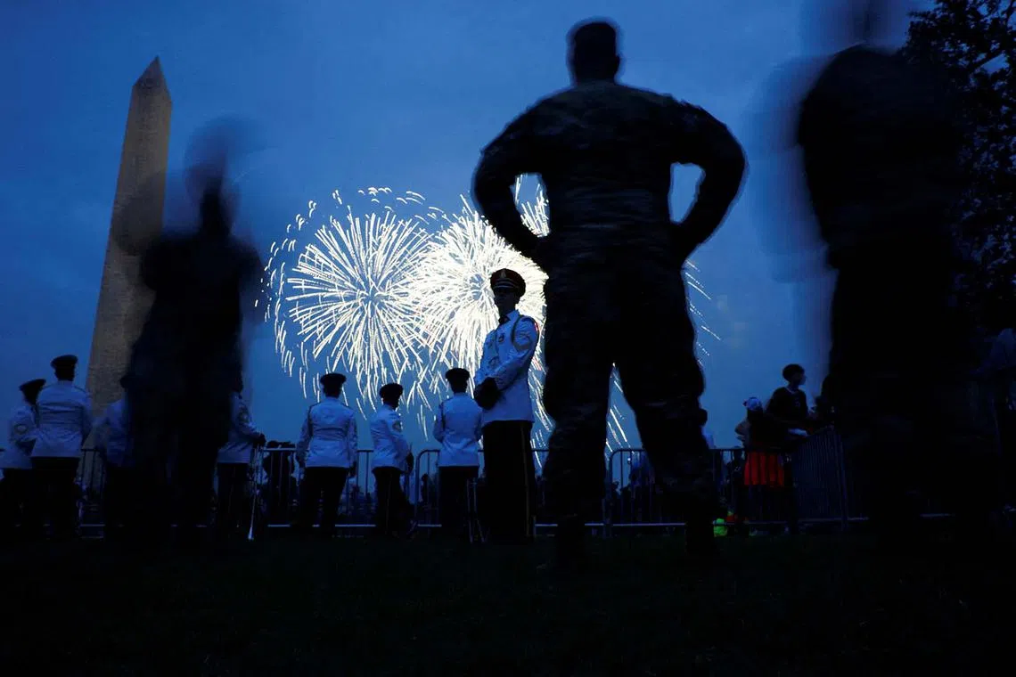 Soldiers and members of a military band watch fireworks explode at the Washington Monument during the U.S. Army’s 250th Birthday Festival in Washington, D.C., US, June 14, 2025. REUTERS/Carlos Barria  TPX IMAGES OF THE DAY