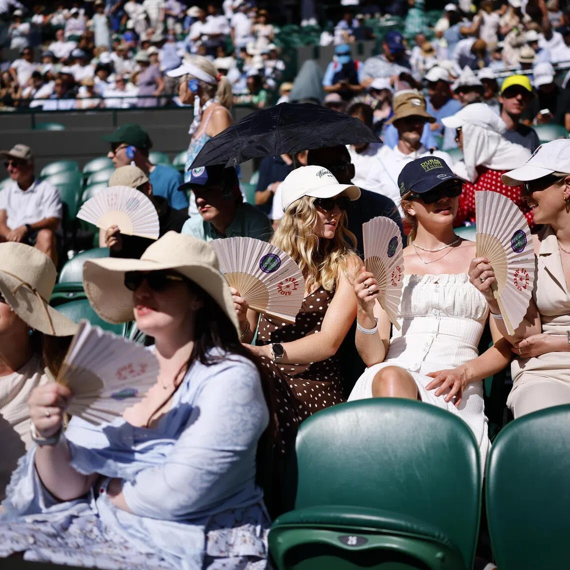 epa13080558 Spectators use fans as they try to keep cool on Court 1 at the Wimbledon Championships in London, Britain, 02 July 2026.  EPA/TOLGA AKMEN