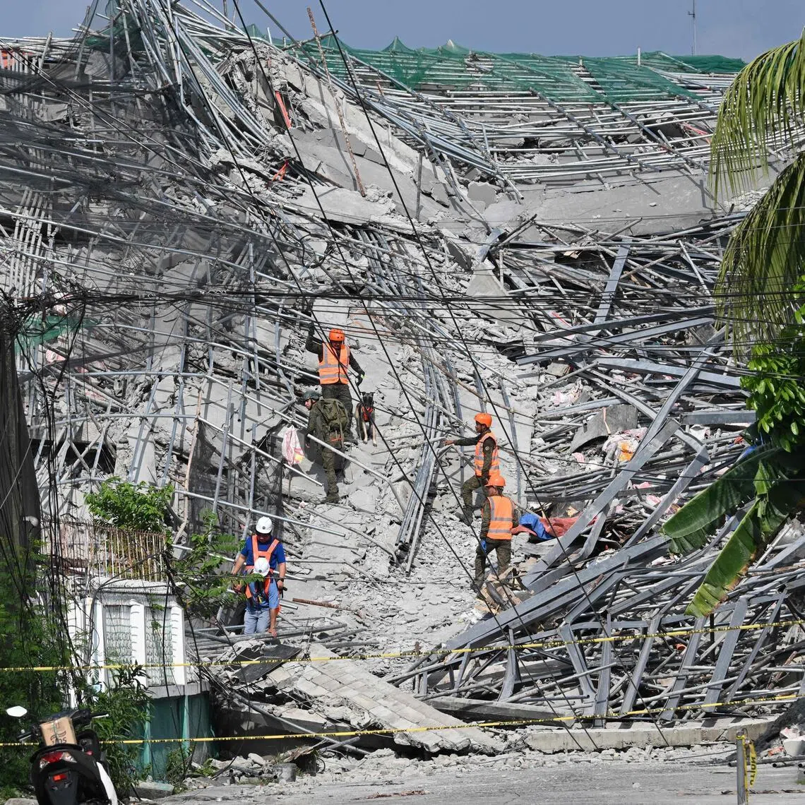 Military personnel with a working dog conduct search and rescue operations at a collapsed building in Angeles City, Pampanga province, north of Manila, on May 25.