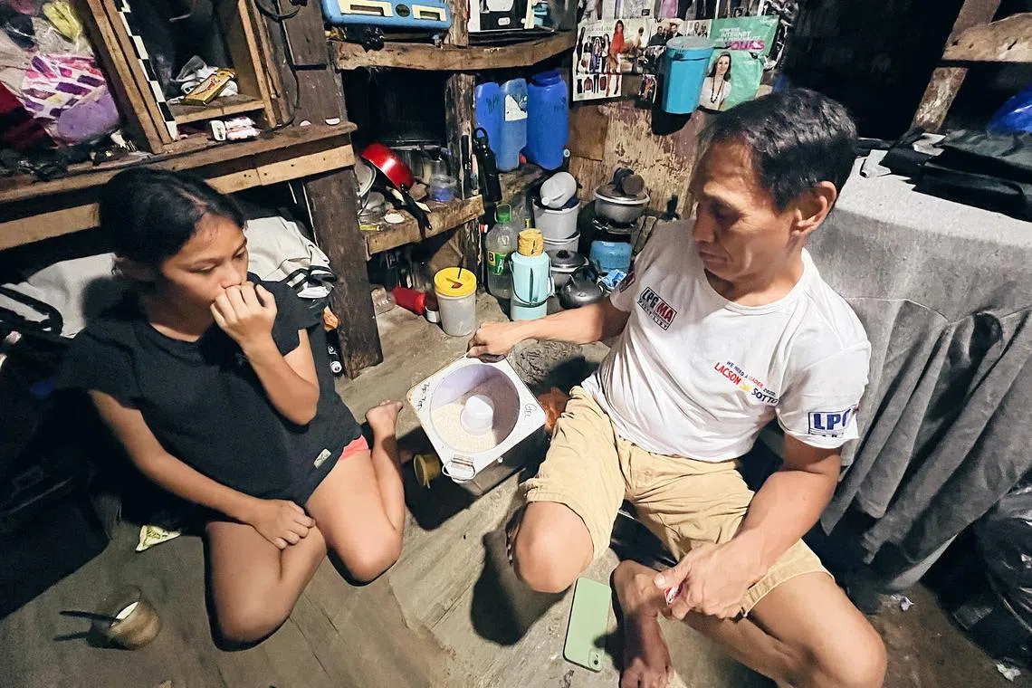Mr Julito Papa and his daughter Janet show what was left of the rice they bought under the food stamp program on September 4, 2023.