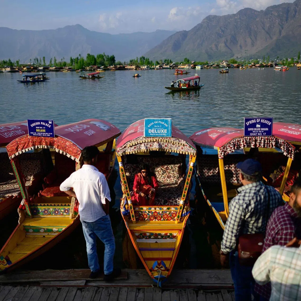 Tourists ride Shikara, a traditional wooden boat at the iconic Dal Lake in Srinagar.