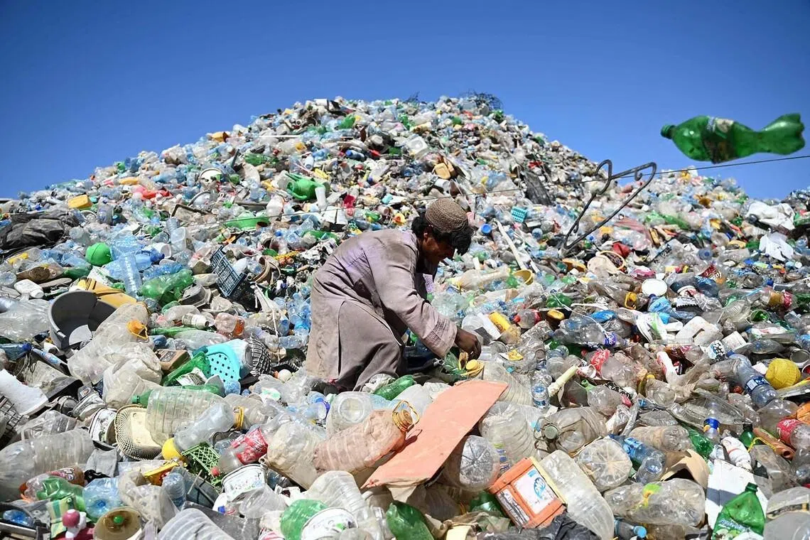 An Afghan worker sorting recyclable materials at a scrapyard in the Kolcha Abad village of Dand district, Kandahar province, on June 23.