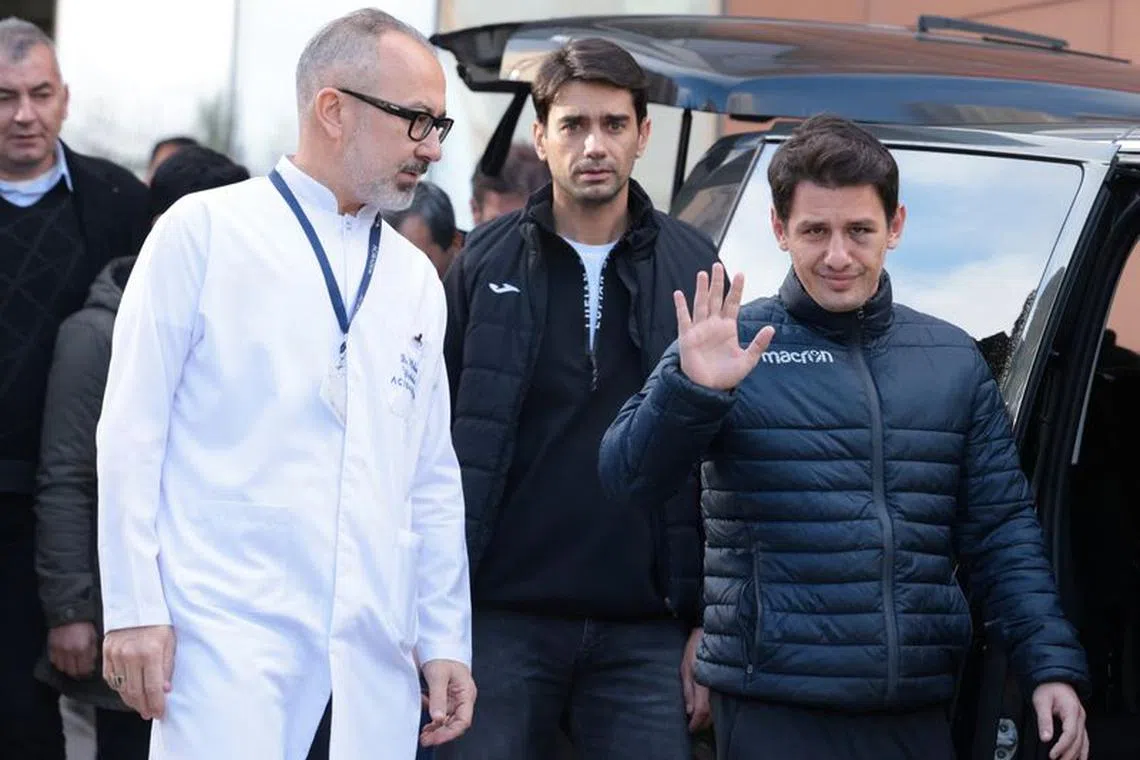 Turkish referee Halil Umut Meler, accompanied by head doctor Mehmet Yorubulut, greets media members as he leaves from a hospital in Ankara, Turkey December 13, 2023. REUTERS/Cagla Gurdogan