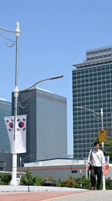 The logo (R top) of Samsung Electronics is seen on the top of a building at the company's headquarters in Suwon on May 22, 2026. Samsung labour union members will begin voting on May 22, on a tentative wage deal that could deliver hefty bonuses to chip workers and helped avert a major strike at the South Korean tech giant this week. (Photo by Jung Yeon-je / AFP)