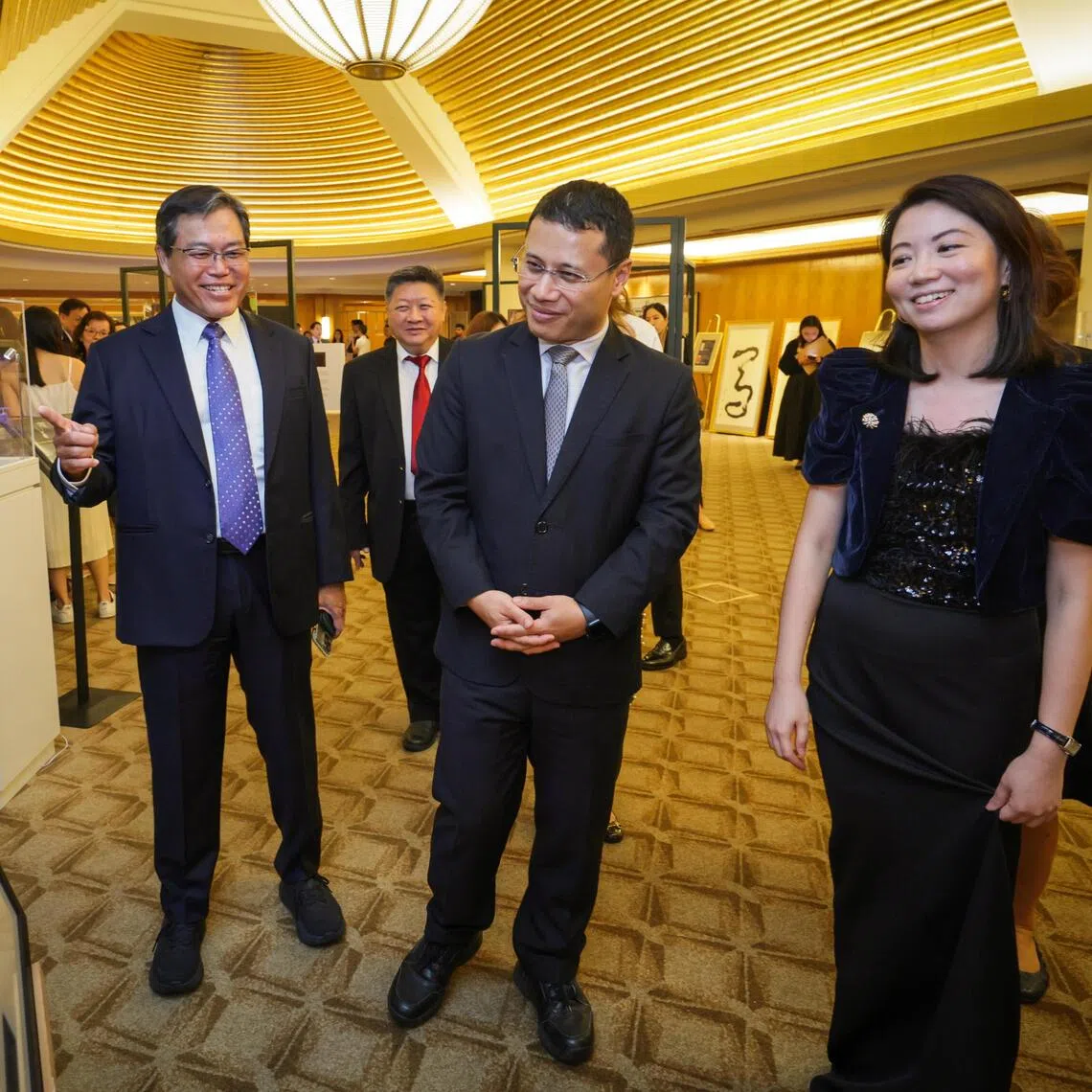 Minister-in-charge of Social Services Integration Desmond Lee (centre) touring the auction booths during the Singapore Children's Society's charity gala dinner on Nov 21. With him are the society's chairman Seah Chin Siong (left) and chief executive Ang Boon Min.