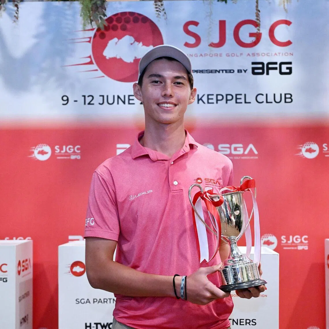 Singapore's Troy Storm holds the Singapore Junior Golf Championship A Boys strokeplay trophy after delivering an eight-stroke victory with a 17-under score of 199.