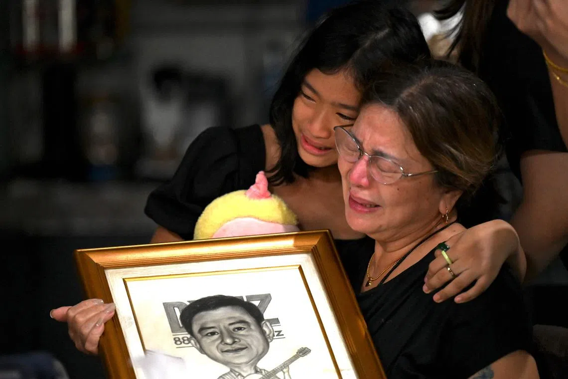 Family members grieve the loss of journalist Percival Mabasa at their home in Las Pinas, suburban Manila on October 4, 2022