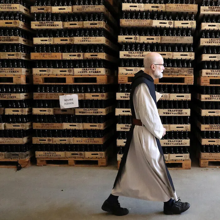 A Belgian trappist monk walking past bottles of Westvleteren beer at the bottling plant in Westvleteren, Belgium, in June 2019.