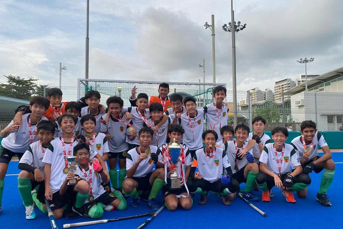 Raffles Institution with the trophy after winning the C Division boys' hockey final at the Sengkang Hockey Stadium on Aug 25. 