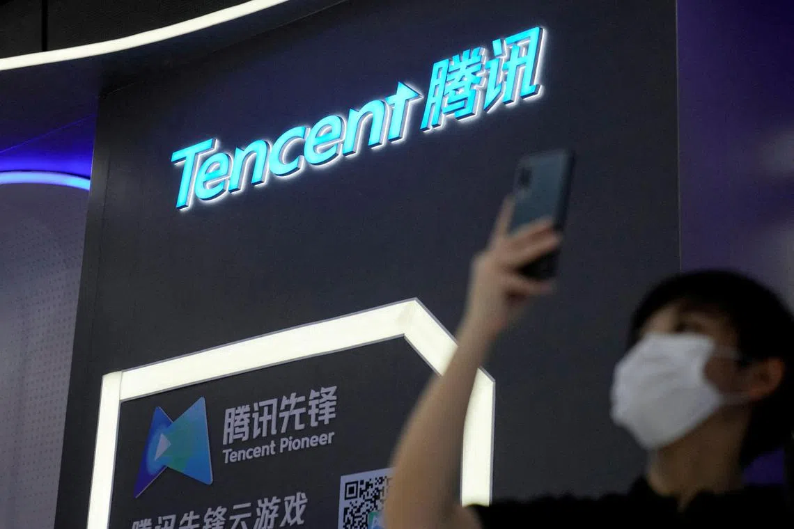 FILE PHOTO: A person stands in front of a sign of Tencent during World Artificial Intelligence Conference, following the coronavirus disease (COVID-19) outbreak, in Shanghai, China, September 1, 2022. REUTERS/Aly Song/File Photo