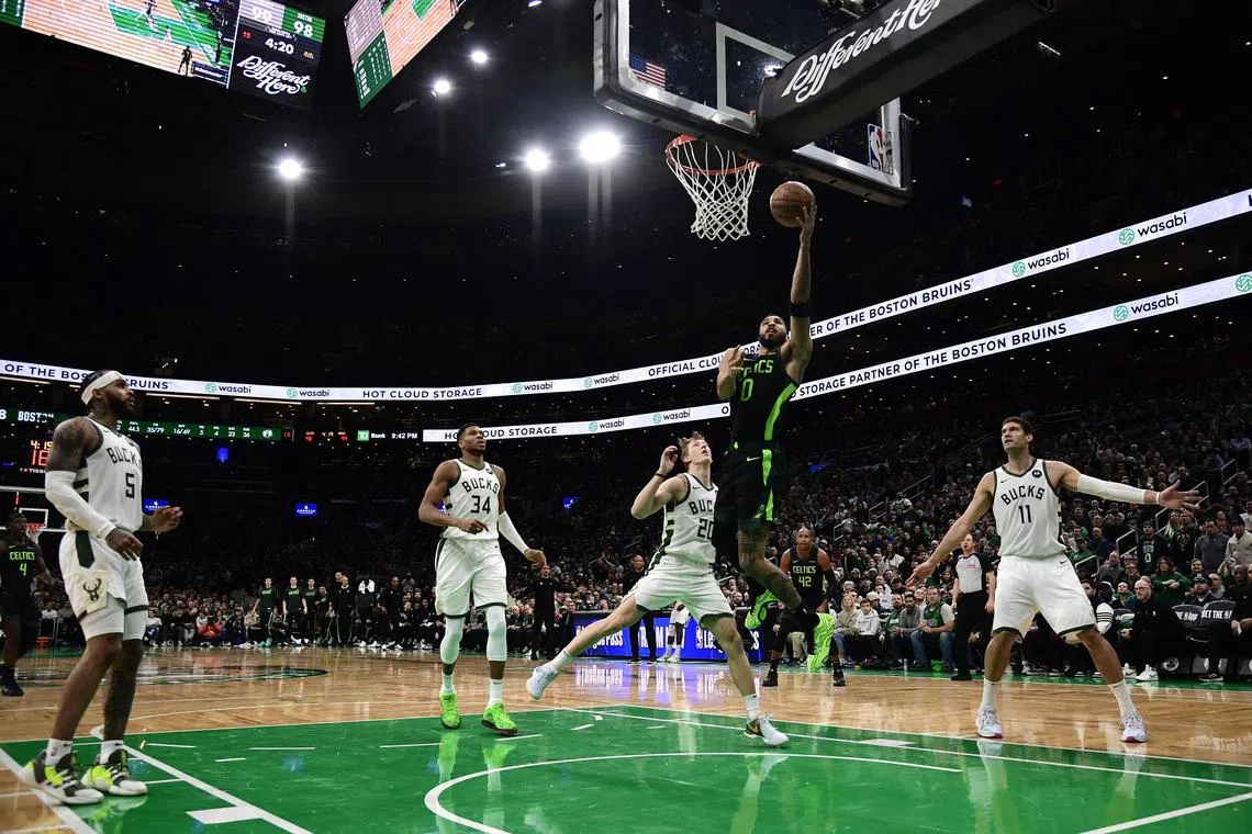 Boston Celtics forward Jayson Tatum lays the ball in the basket past Milwaukee Bucks guard AJ Green during the second half at TD Garden. 