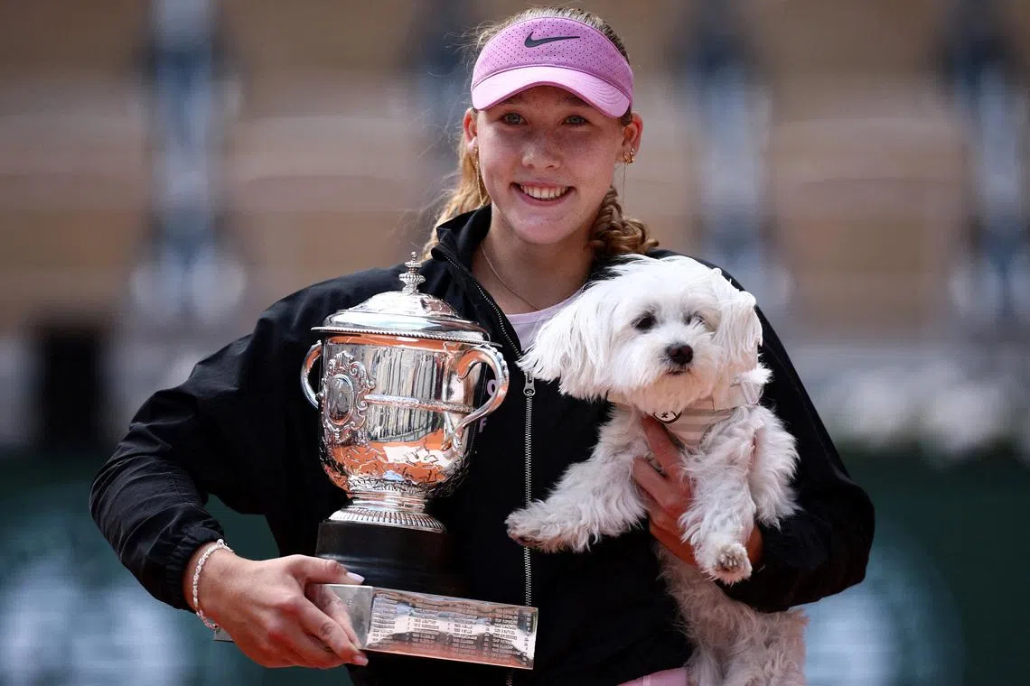 Tennis - French Open - Roland Garros, Paris, France - June 6, 2026 Russia's Mirra Andreeva celebrates with the trophy and a dog after winning her final match against Poland's Maja Chwalinska REUTERS/Guglielmo Mangiapane