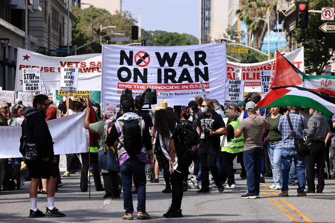 FILE PHOTO: A \"No war on Iran\" banner is held as people attend an anti-war demonstration in Los Angeles, California, U.S., June 21, 2025. REUTERS/David Swanson/File Photo
