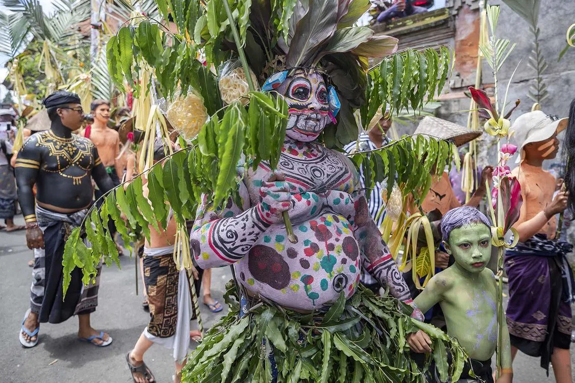 Gede Pasek (centre), with his body painted, marching during the sacred Ngerebeg ritual at the Tegallalang village in Gianyar, Bali, Indonesia, April 3, 2024.