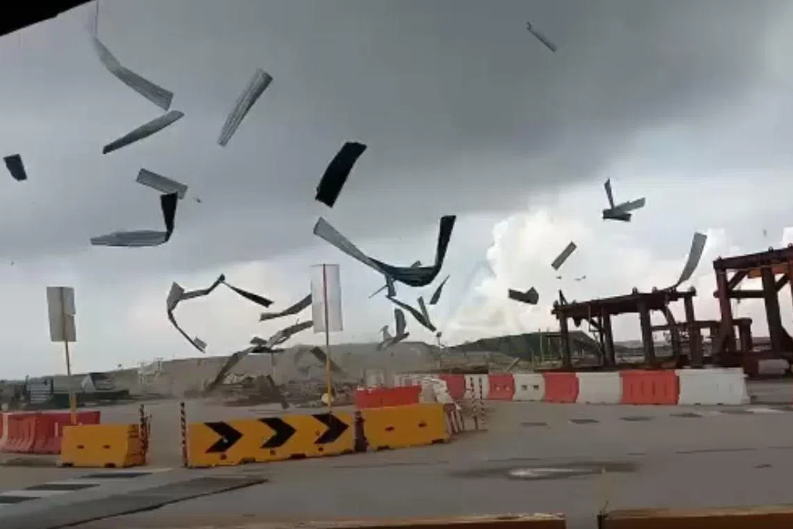 Debris was seen being lifted into the air in an upward, circular motion, with dark clouds looming over the construction site.