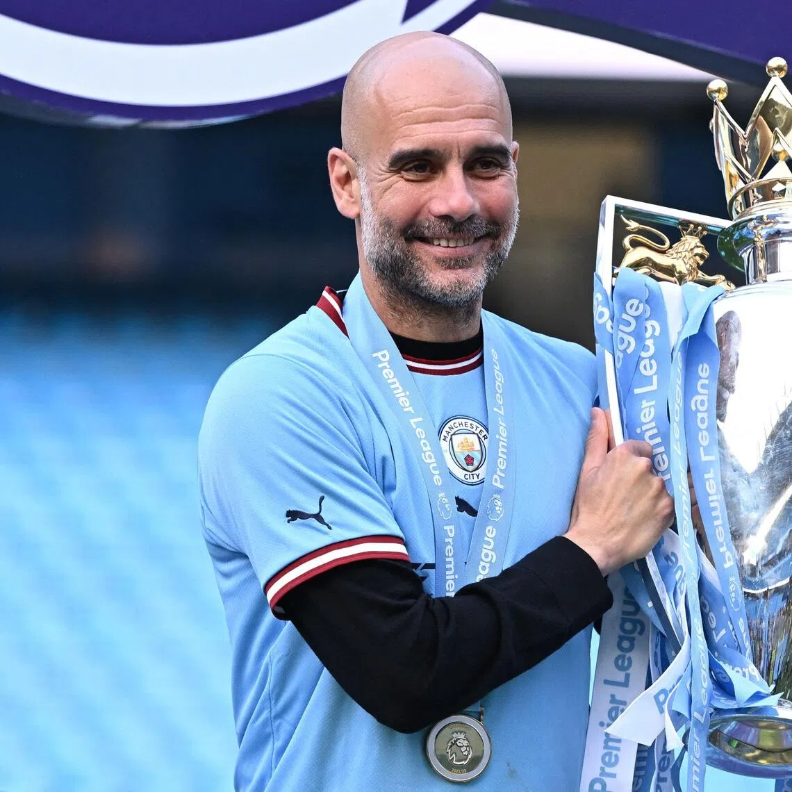 Former Manchester City manager Pep Guardiola poses with the Premier League trophy in 2023.