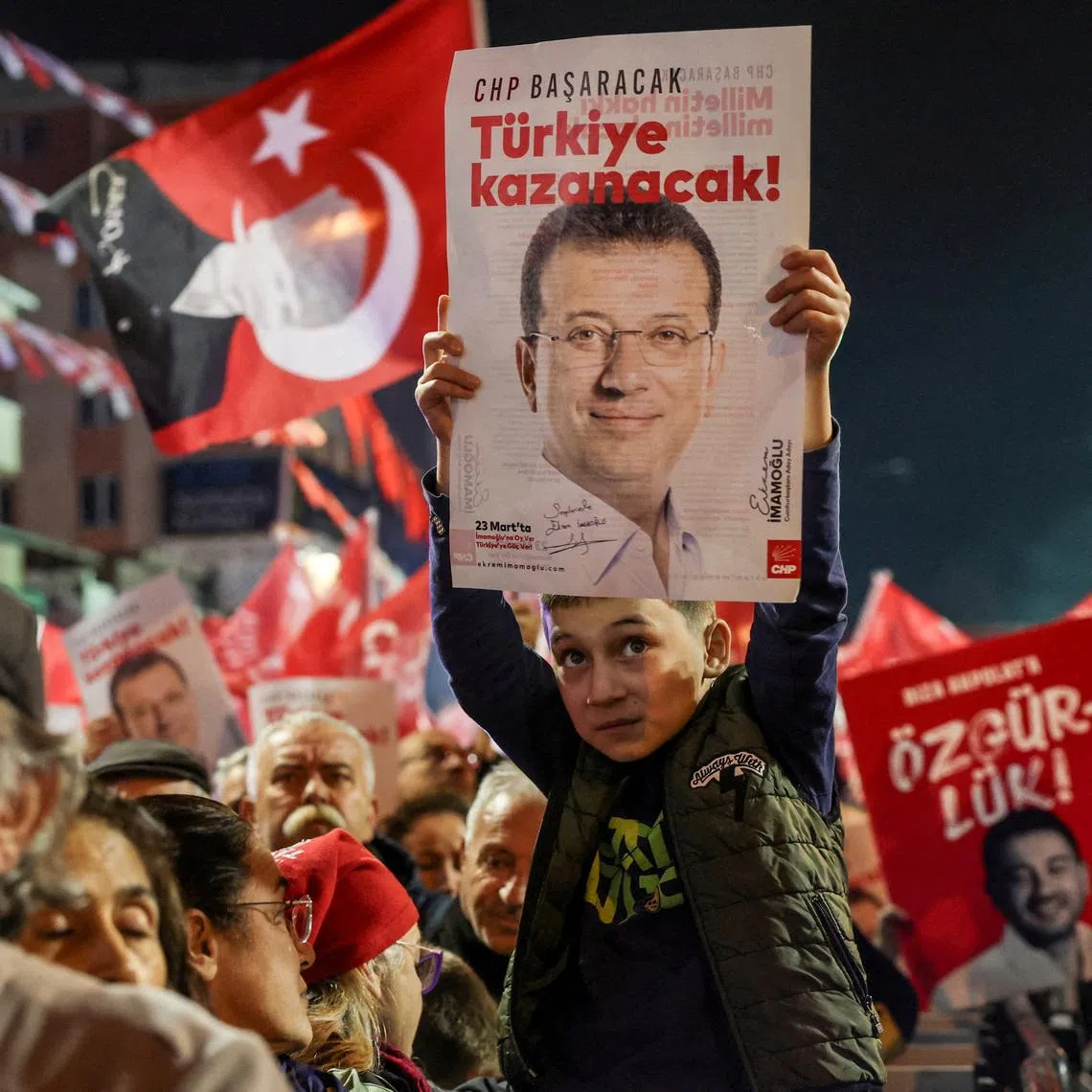 A supporter of Turkey's main opposition Republican People's Party (CHP) holds a poster with a picture of jailed Istanbul Mayor Ekrem Imamoglu with a slogan reading, during a rally in support of Imamoglu in Istanbul, Turkey, November 12, 2025.