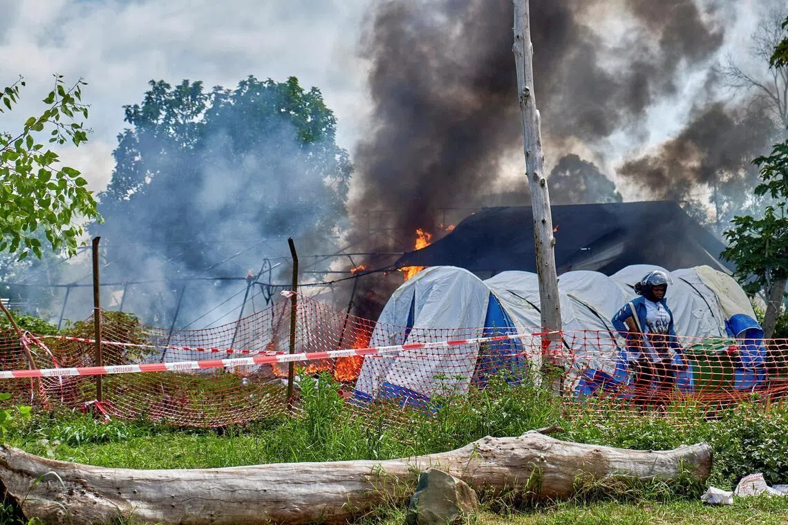 A crowd set fire to Ebola treatment tents in Rwampara, Democratic Republic of Congo, on May 21, after soldiers fired tear gas and warning shots to defuse tensions over the burial of a local footballer who had died from the disease.