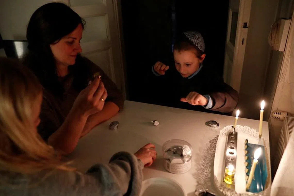 Liora Ruth, a Hungarian-born Jewish musician, who have come to Hungary from Israel after the October 7 attacks, celebrates the first night of the Jewish holiday of Hanukkah with her children, in Budapest, Hungary, December 7, 2023. REUTERS/Bernadett Szabo