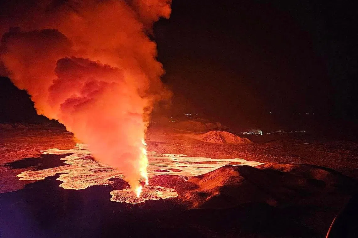 Billowing smoke and flowing lava are seen expelling from a new fissure on Feb 8, 2024, during a new volcanic eruption on the outskirts of the evacuated town of Grindavik, western Iceland. 