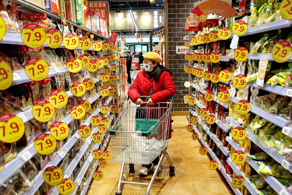 A customer browsing through products at a supermarket in Lianyungang, in eastern China's Jiangsu province on Jan 9, 2025. 