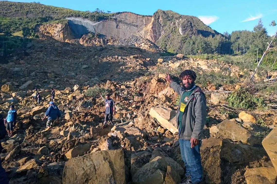 People gather at the site of a deadly landslide in Papua New Guinea's Enga province on May 24, 2024.
