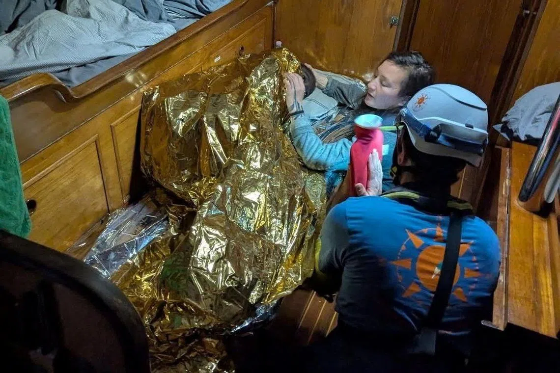 A Compass Collective volunteer assists an eleven-year-old girl from Sierra Leone, the sole survivor of a shipwreck off Italy's Lampedusa Island, on board of rescue vessel Trotamar III in this handout picture released on December 11, 2024. Compass Collective/Handout via REUTERS