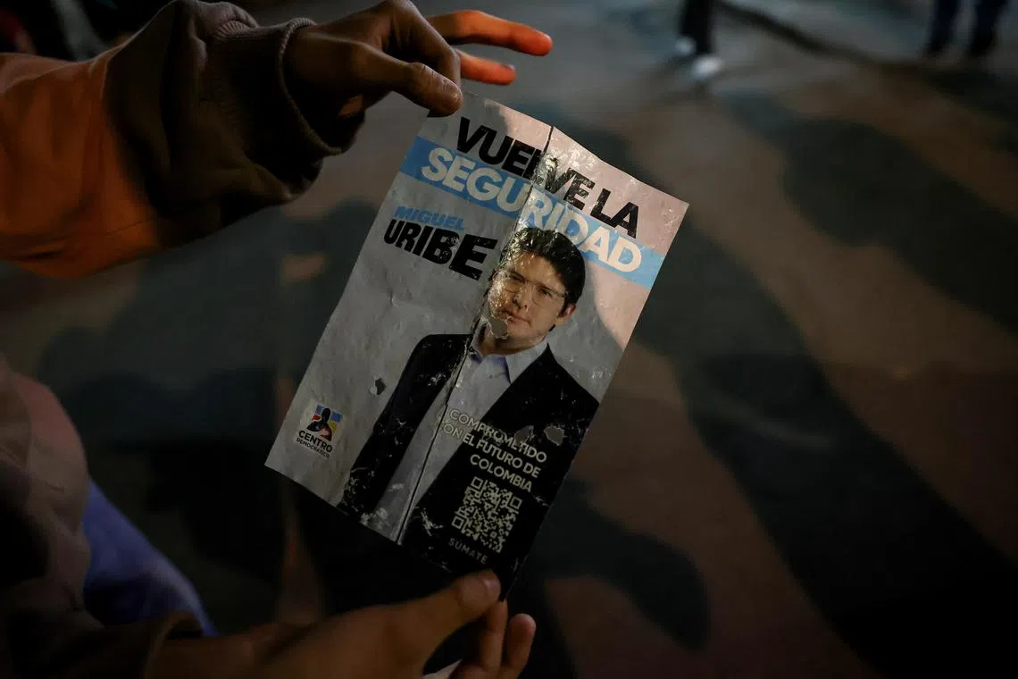 A person holding a campaign poster at the area where Colombian Senator Miguel Uribe Turbay was shot during a campaign event on June 7.
