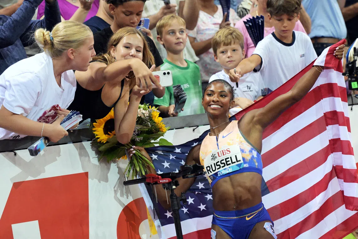 FILE PHOTO: Athletics - Diamond League - Zurich - Letzigrund, Zurich, Switzerland - August 27, 2026 Masai Russell of the U.S. poses for selfies with spectators after winning the women's 100m hurdles final and setting a new world record REUTERS/Romina Amato/File Photo