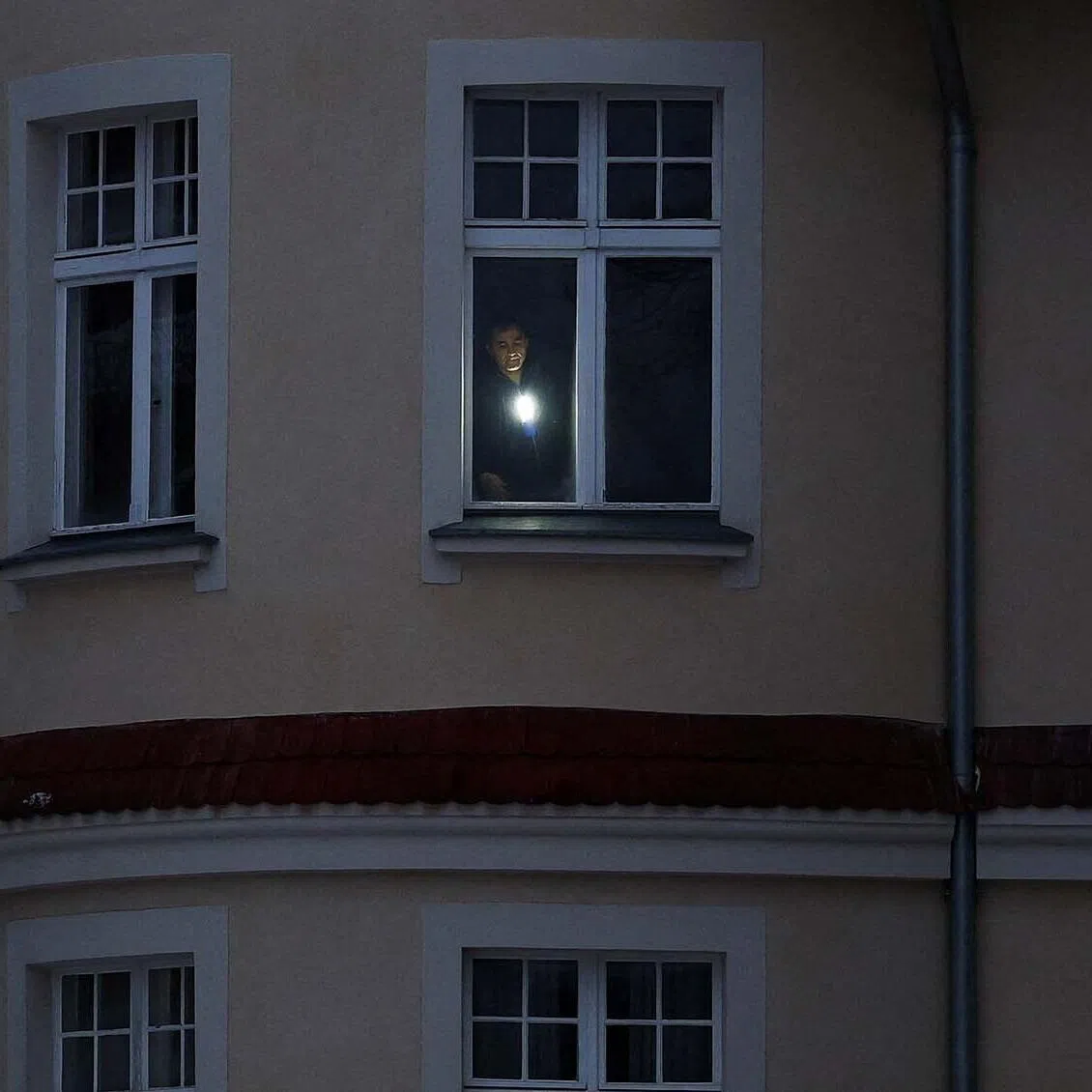 A man uses a torch in his apartment during a blackout that left thousands of homes without electricity after a suspected arson attack at the power plant Lichterfelde, in the district Steglitz-Zehlendorf, in southern Berlin, Germany, January 4, 2026. REUTERS/Lisi Niesner TPX IMAGES OF THE DAY