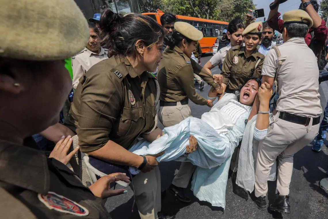 Indian security personnel detain a member of the opposition Aam Aadmi Party during a protest in New Delhi on March 22.