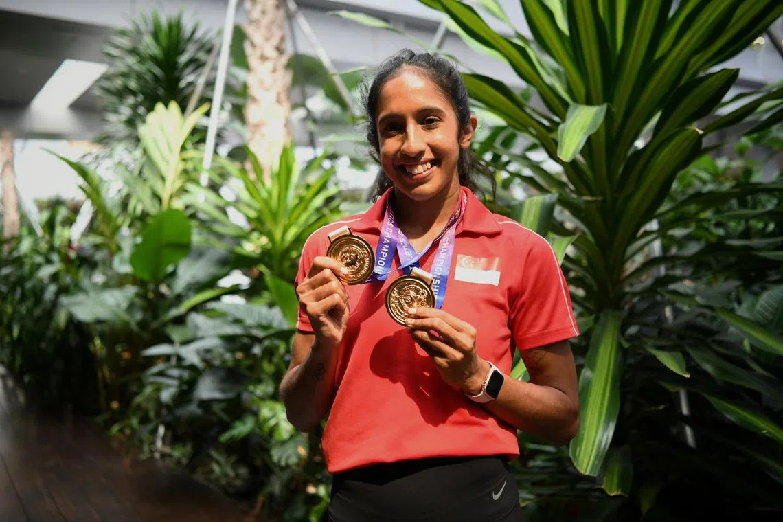 Shanti Pereira posing with her Asian Athletics Championships gold medals at Changi Airport on July 17, 2023.