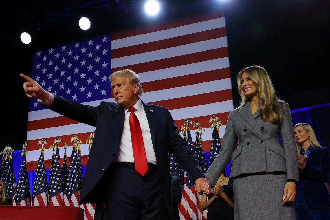 Republican presidential nominee and former U.S. President Donald Trump gestures as he holds hands with his wife Melania during his rally, at the Palm Beach County Convention Center in West Palm Beach, Florida, U.S., November 6, 2024. REUTERS/Brian Snyder