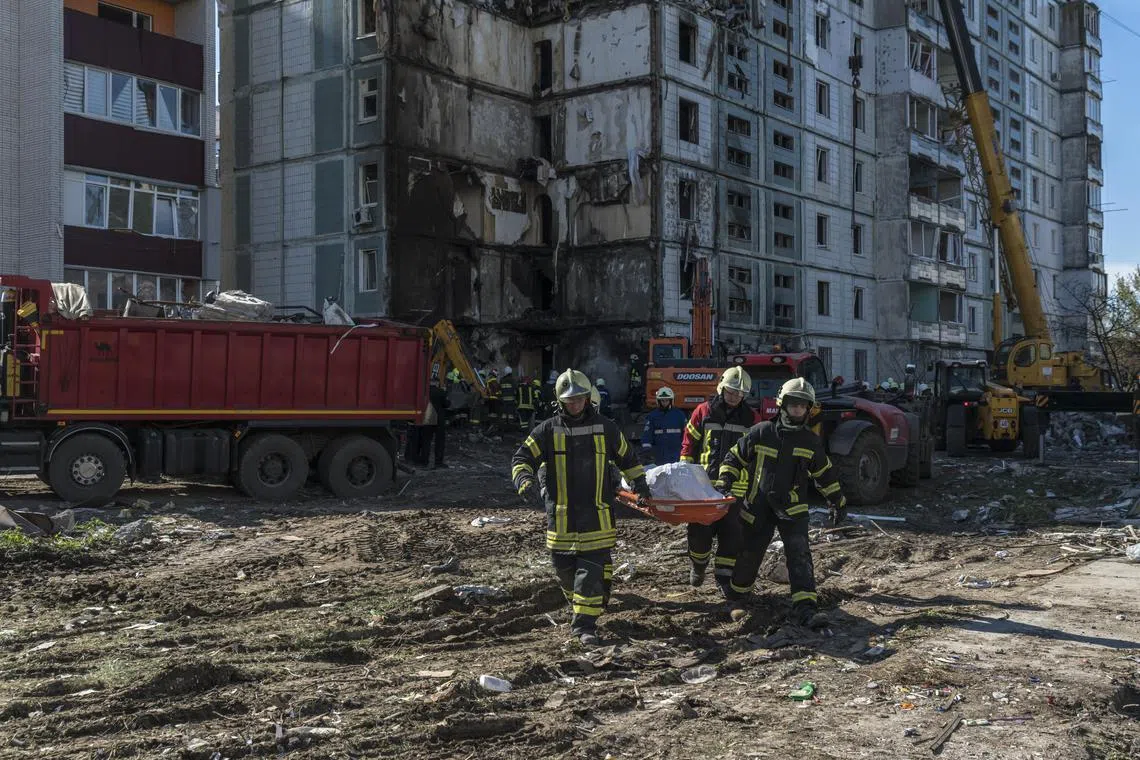 Emergency workers remove the body of a victim from the rubble in Uman, Ukraine, on April 28.