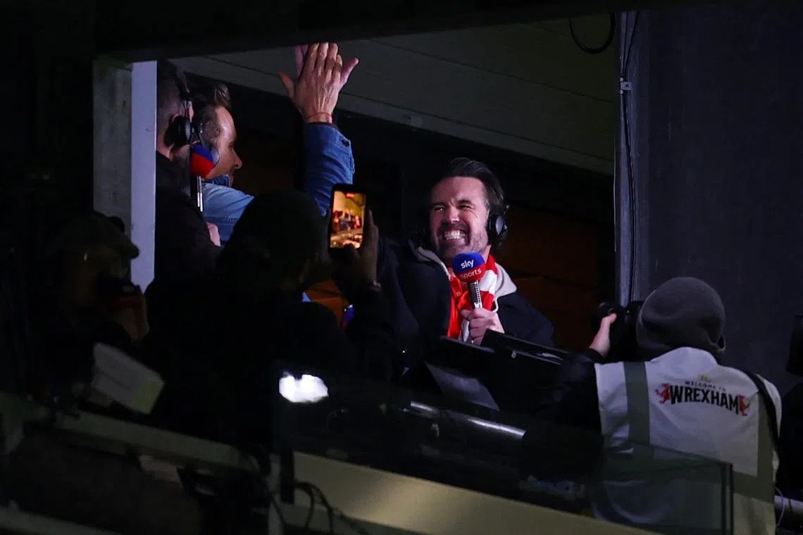 Wrexham co-owners Rob McElhenney and Ryan Reynolds celebrate after Nathan Broadhead scores during Wrexham's win over Swansea in the Championship on March 13.