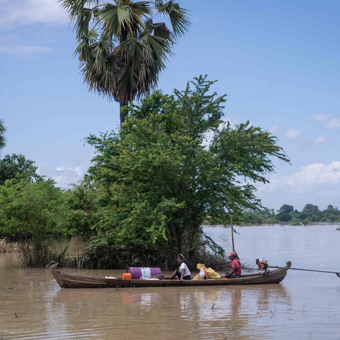 Residents travel by boat through floodwaters in Wetlet, Myanmar.