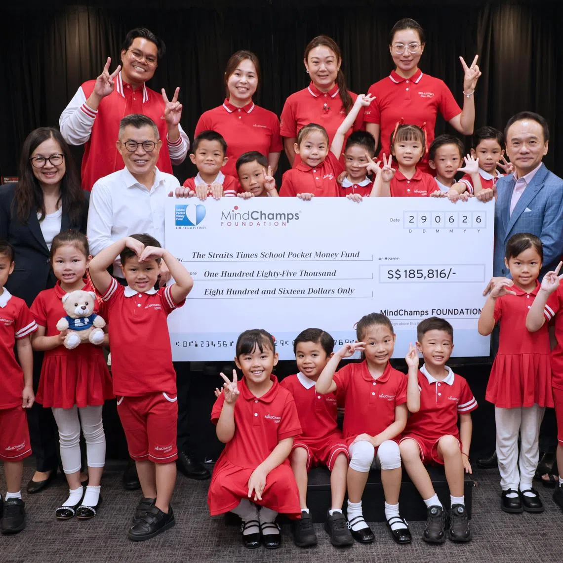 ST editor Jaime Ho (middle row, second from left) receiving the mock cheque from MindChamps founder David Chiem.