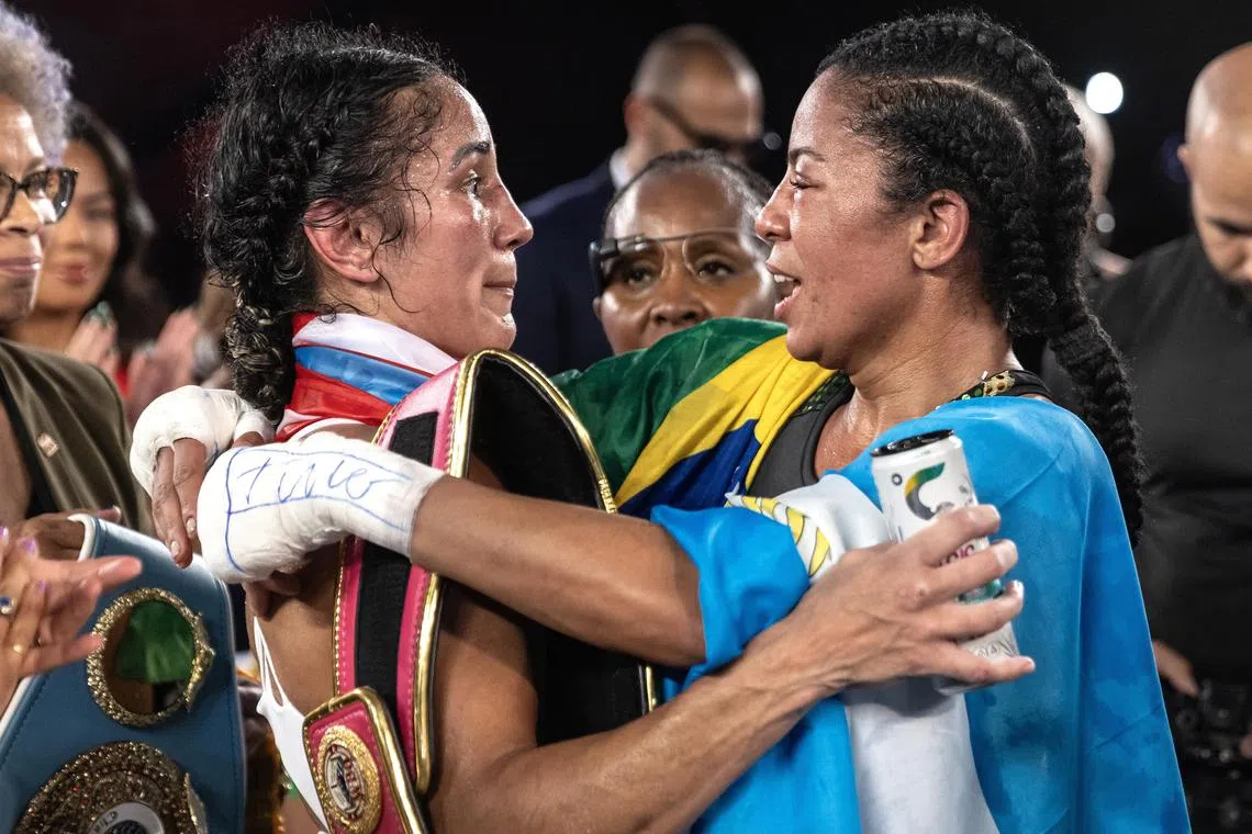 Puerto Rico's Amanda Serrano (left) speaking with Brazil’s Danila Ramos after she won their first-ever women’s unified title bout of 12 three-minute rounds at the Caribe Royale Resort in Orlando, Florida, on Friday.