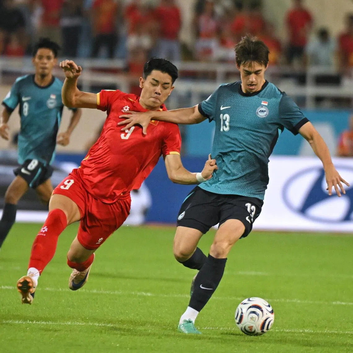 Singapore’s Harhys Stewart keeping Vietnam’s Nguyen Dinh Bac at bay during the ASEAN Championship Group A match at the My Dinh National Stadium on July 31 as Lionel Tan (No. 15) and Shah Shahiran look on.