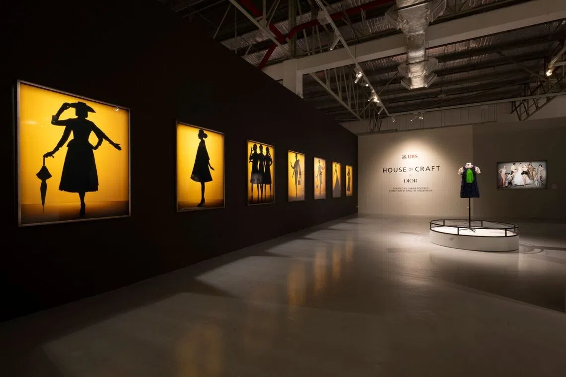 An installation view of UBS House of Craft x Dior in Singapore, featuring newly unveiled photographs by Brigitte Niedermair and archival couture pieces curated by Carine Roitfeld.