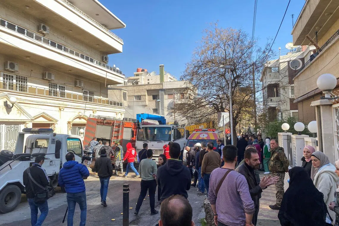 People gather near the site in Damascus that sources say was hit by an Israeli military strike on Jan 20.